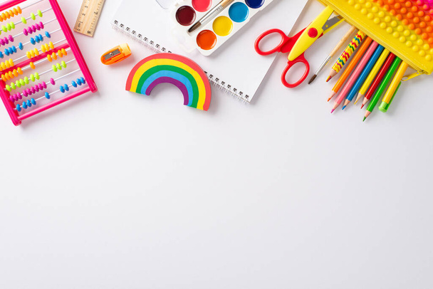 Explore wonders of early childhood education with this top-down perspective: arrangement of colorful child stationery on white isolated background, providing copyspace for text or promotional material - Photo, Image