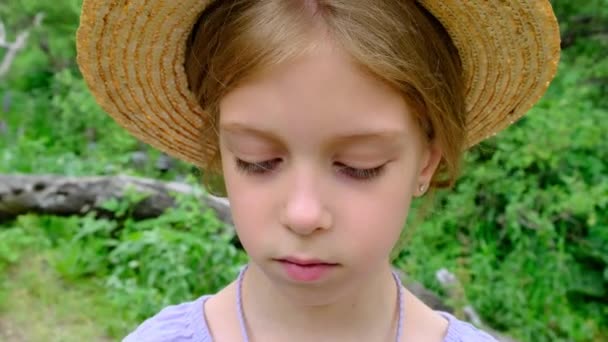 藁帽子の動揺した少女の肖像画は悲しいことに下を向いています。高品質4k映像 - 映像、動画