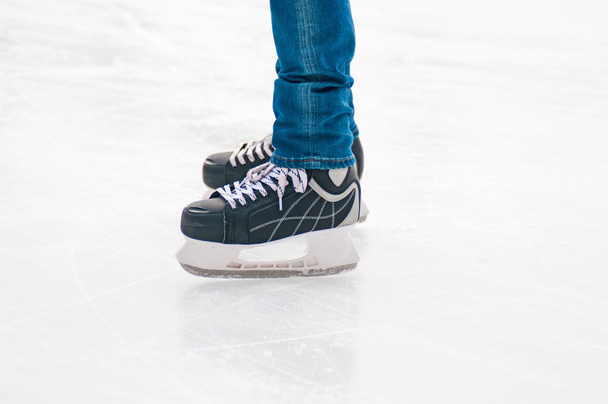 Legs of skater on winter ice rink - Fotoğraf, Görsel