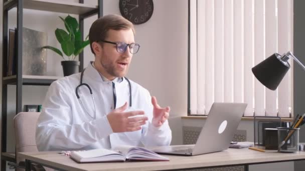 Fiatal terapeuta egy online konzultáción az irodában. Az orvos online konzultál a beteggel. tabletták - Felvétel, videó