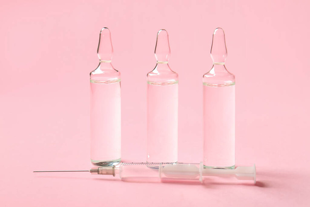 Medical ampules on pink background - 写真・画像