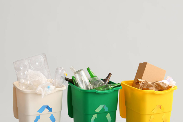 Containers with different types of garbage on light background. Recycling concept - Photo, Image