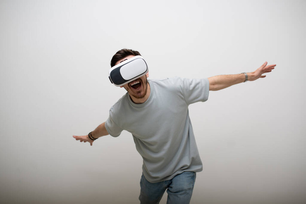 Futurystyczny człowiek w okularach rzeczywistości wirtualnej współdziała z powietrzem w odizolowanym szarym tle. Wysokiej jakości zdjęcie - Zdjęcie, obraz