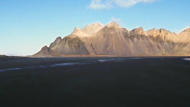 Aerial view of stokksnes sand beach in icelandic scenery, majestic vestrahorn mountains in arctic landscape. Spectacular iceland panoramic view with atlantic ocean shore, coastline. Slow motion. - Photo, Image