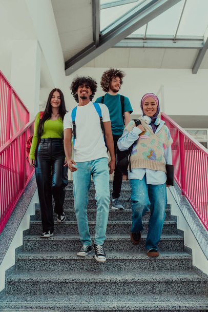 Μια ομάδα διαφορετικών φοιτητών, συμπεριλαμβανομένου ενός Αφροαμερικανού άνδρα και μιας μουσουλμάνας κοπέλας που φορούν χιτζάμπ, περπατούν μαζί στους σύγχρονους διαδρόμους του πανεπιστημίου, συμβολίζοντας την εγκλειστικότητα και τη δύναμη του - Φωτογραφία, εικόνα