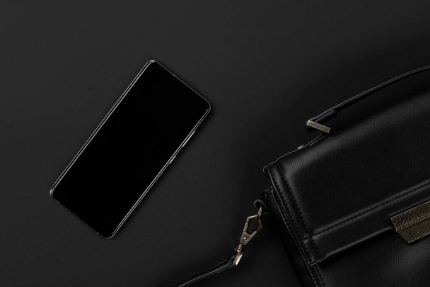 Flat lay top view bag and smartphone on black background. Black friday thanksgiving christmas template fashion shopping sale mockup - Fotoğraf, Görsel