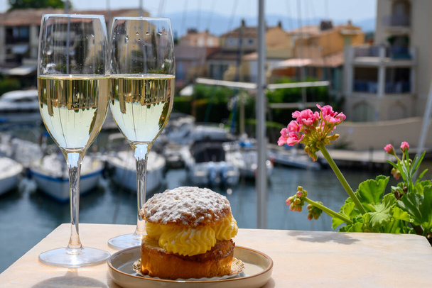 Beber vino espumoso de champán francés brut con pastel Tarte Tropezienne, fiesta club en el puerto deportivo de Port Grimaud cerca de Saint-Tropez, vacaciones Riviera Francesa, Var, Francia - Foto, Imagen