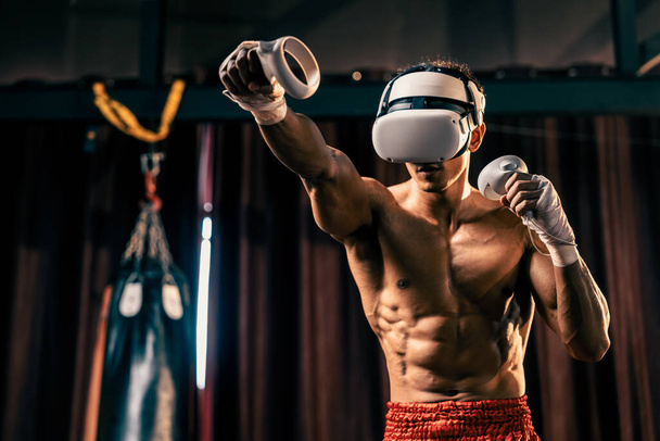 Boxer training utilizing VR technology or virtual reality, wearing VR headset with immersive boxing training technique using controller to enhance his skill in boxing simulator environment. Impetus - 写真・画像