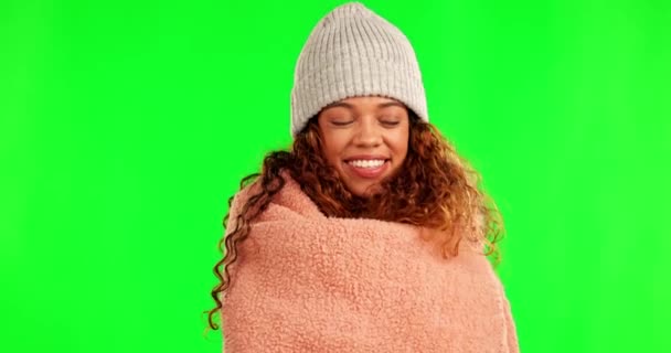 Dekentje, knus en gezicht van een vrouw op een groen scherm geïsoleerd op een achtergrond in een studio. Gelukkig, comfortabel en portret van een jong meisje met warmte en geluk van een dekbed voor comfort in de winter. - Video