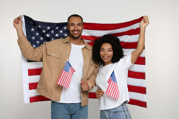 4th of July - Independence Day of USA. Happy couple with American flags on white background - Фото, изображение