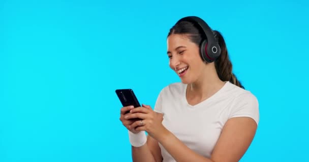 オーディオプレイリストをストリーミングスタジオで青の背景に女性と電話、音楽、ダンス。幸せな若い女性と携帯電話、ラジオやヘッドフォンは、インターネットアプリを使用して音を聞く. - 映像、動画