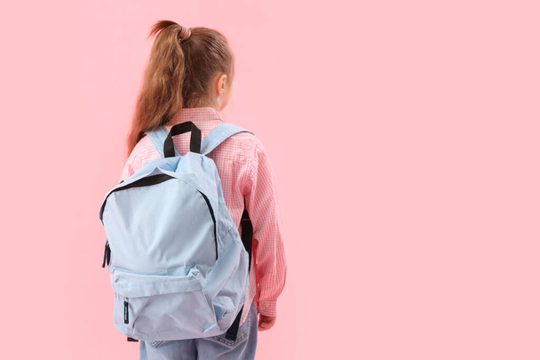 Little schoolgirl with backpack on pink background, back view - Foto, Imagem