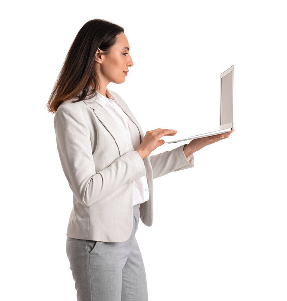 Mladá podnikatelka ve stylovém obleku pomocí notebooku na bílém pozadí - Fotografie, Obrázek
