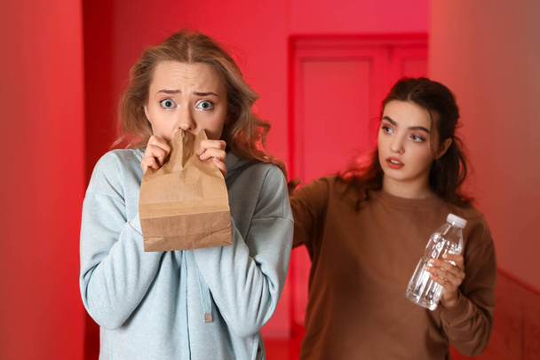 Woman giving water to girl who is having panic attack - Photo, Image