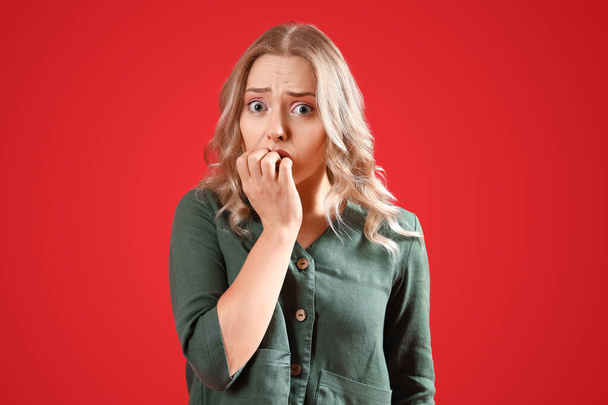 Young woman having panic attack on red background - Photo, Image
