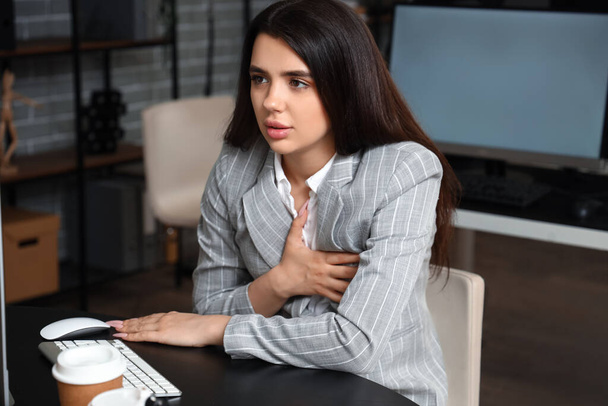 Jonge vrouw met paniekaanval op kantoor - Foto, afbeelding