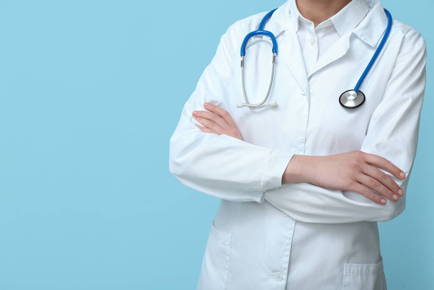 Žena lékař v bílém kabátě se stetoskopem na modrém pozadí - Fotografie, Obrázek