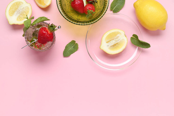 Glass of fresh lemonade with strawberry and lemon on pink background - Photo, Image