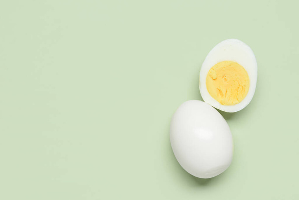 Tasty boiled egg with half on green background - 写真・画像