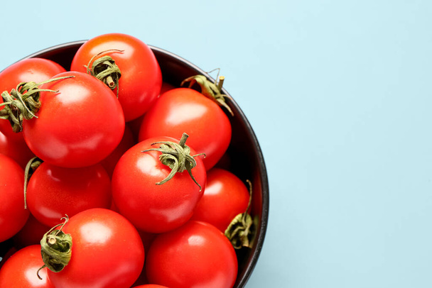 Bowl with fresh cherry tomatoes on blue background - Photo, Image