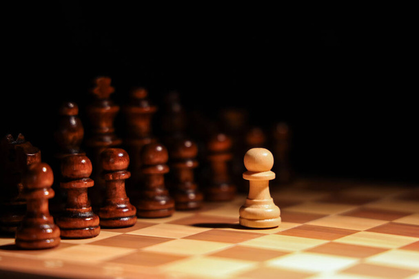 Game board with wooden chess pieces on dark background, closeup - 写真・画像
