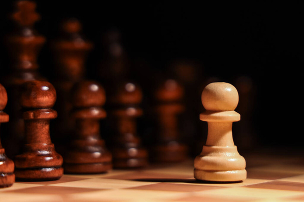 Game board with chess pieces on dark background, closeup - Fotó, kép