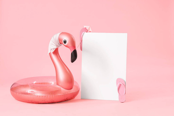 Pusty plakat z nadmuchiwanym pierścieniem w kształcie flaminga na różowym tle. Koncepcja podróży - Zdjęcie, obraz