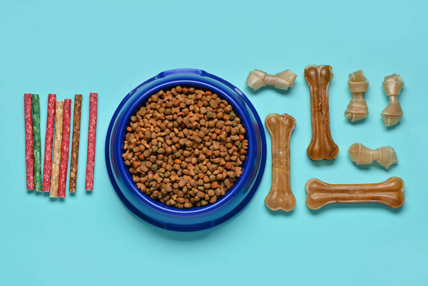 Composition with different dog treats and dry food on color background - Photo, Image