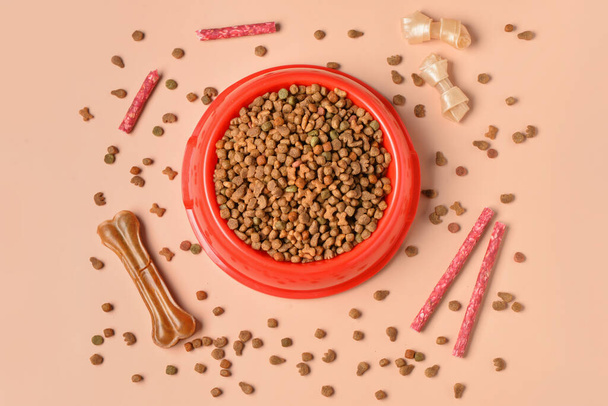 乾燥犬の食べ物や色の背景に異なる御馳走のボウルと組成物 - 写真・画像