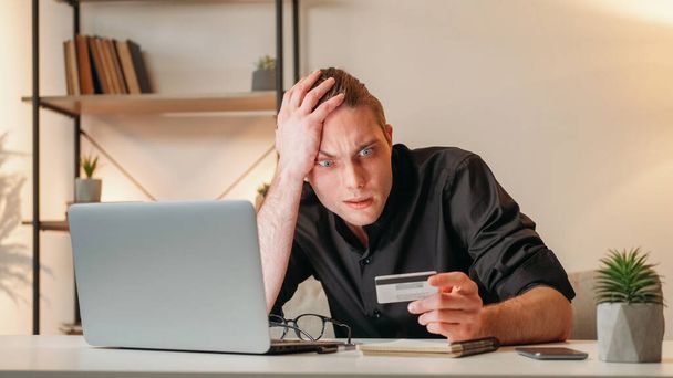 Bank scam. Financial fraud. Money transaction risk. Frustrated overwhelmed stressed business man with credit card laptop at workplace interior with free space. - Photo, Image