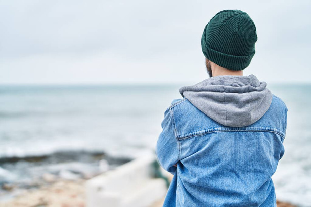 Jovem careca de pé na visão traseira à beira-mar - Foto, Imagem