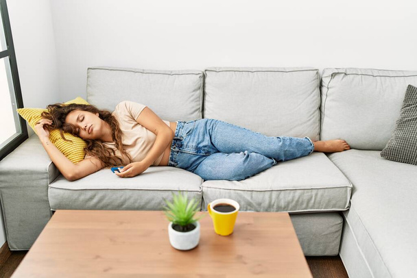 Νεαρή όμορφη Ισπανίδα ξαπλωμένη στον καναπέ και κοιμάται στο σπίτι - Φωτογραφία, εικόνα