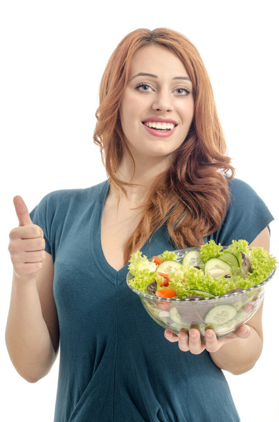Une femme heureuse qui mange de la salade. Femme gardant un régime avec une salade verte et approuvant les aliments crus biologiques
 - Photo, image