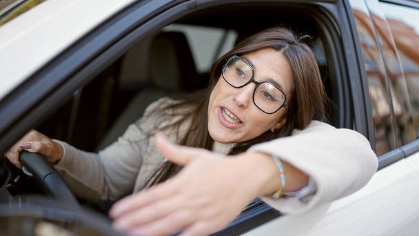 Young beautiful hispanic woman stressed driving car at street - Foto, afbeelding
