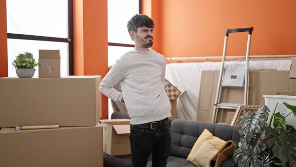 Fiatal spanyol férfi mozog hátfájással az új otthonban - Fotó, kép