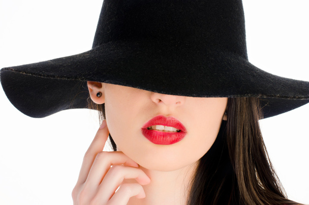 Woman with a big black hat covering her eyes. Beautiful perfect red lips, sexy mouth - 写真・画像