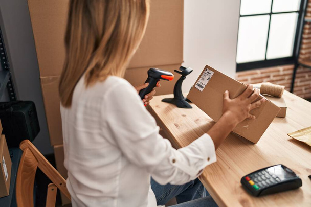 Young hispanic woman ecommerce business worker scanning package at office - Photo, Image