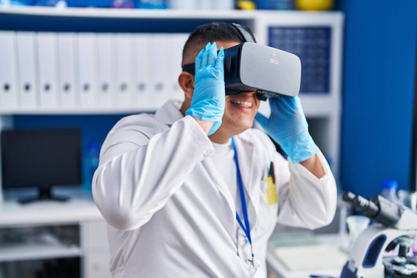 Jonge Latijnse man wetenschapper met behulp van virtual reality bril in het laboratorium - Foto, afbeelding