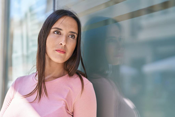 Молода красива іспаномовна жінка дивиться на бік з серйозним виразом на вулиці
 - Фото, зображення