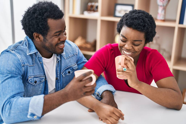 Afričan Američan muž a žena pár pití kávy sedí na stole doma - Fotografie, Obrázek
