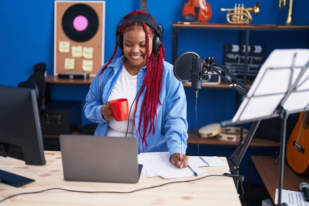 アフリカ系アメリカ人女性アーティストが音楽スタジオでコーヒーを飲む - 写真・画像