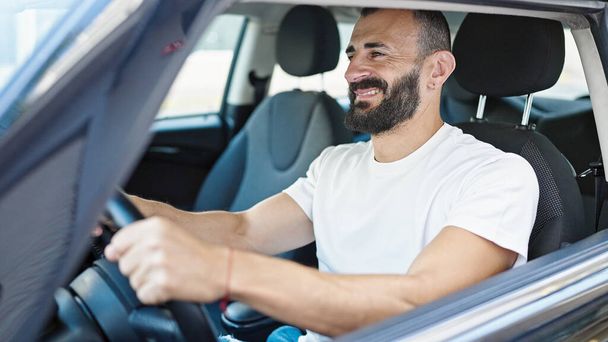 Young hispanic man smiling confident driving car at street - Foto, Imagem