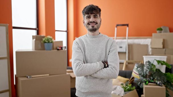 Young hispanic man smiling confident with crossed arms at new home - Photo, Image