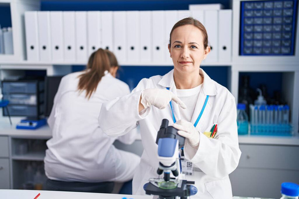 Blonde woman working on cruelty free laboratory pointing finger to one self smiling happy and proud  - Фото, зображення