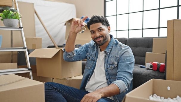 Afrikai amerikai férfi mosolygós magabiztos gazdaság új ház kulcsait az új otthon - Fotó, kép