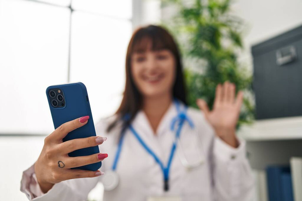 Young beautiful hispanic woman doctor smiling confident having video call at clinic - Foto, Bild