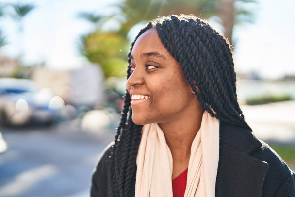 Африканська американка усміхається з упевненістю, дивлячись убік на вулиці. - Фото, зображення