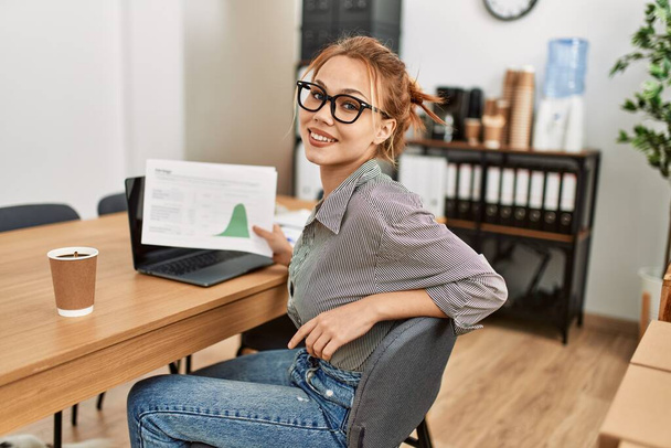オフィスでノートパソコンを持っている若い白人女性のビジネスワーカー - 写真・画像