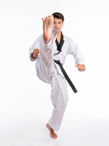 Taekwondo high kick - black belt  taekwondo athlete martial arts master , handsome man show high kick pose during fighter training isolated on white background - Foto, imagen
