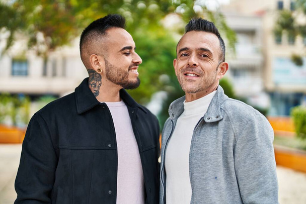 Two men couple smiling confident standing together at park - Fotoğraf, Görsel